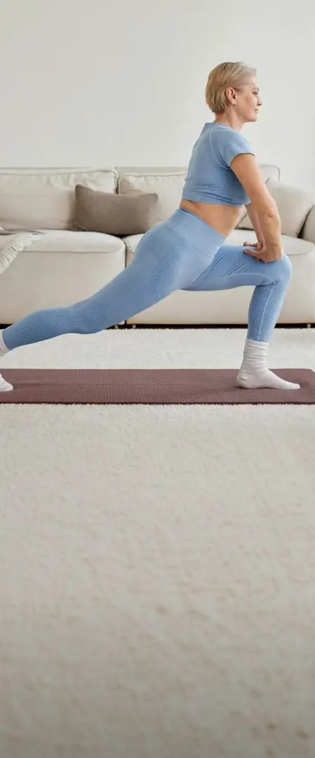 Woman doing a lunge stretch on a yoga mat at home