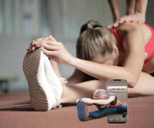 A photo of a female athlete doing a seated hamstring stretch as part of an injury prevention routine.