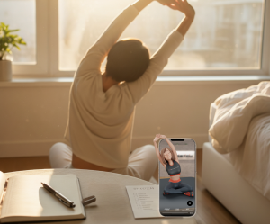 A photo of a woman stretching her arms overhead while sitting on the floor by a sunny bedroom window with a journal on the table.
