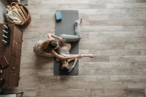 A photo of a pregnant woman receiving guided side-lying stretches to ease back pain.