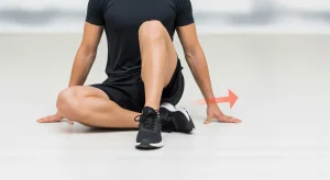 A photo of a seated 90/90 internal hip rotation stretch demonstrating controlled hip mobility.