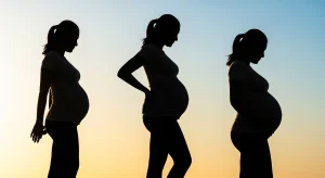An image of a pregnant woman stretching with WeStretch app instructions on the screen beside her.