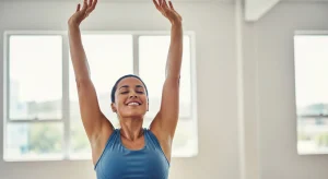 An image of a person raising arms overhead after stretching to relieve shoulder blade tension and stiffness.