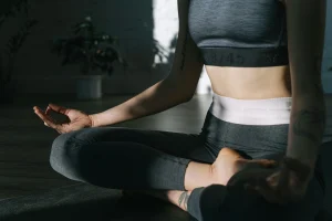 An image of a person sitting cross-legged in a calm seated stretch, focusing on breathing and posture.