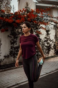 An image of a runner standing and stretching their quadriceps on a sidewalk before running.
